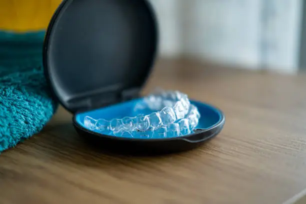 A clear aligner case on a tidy, bright desk