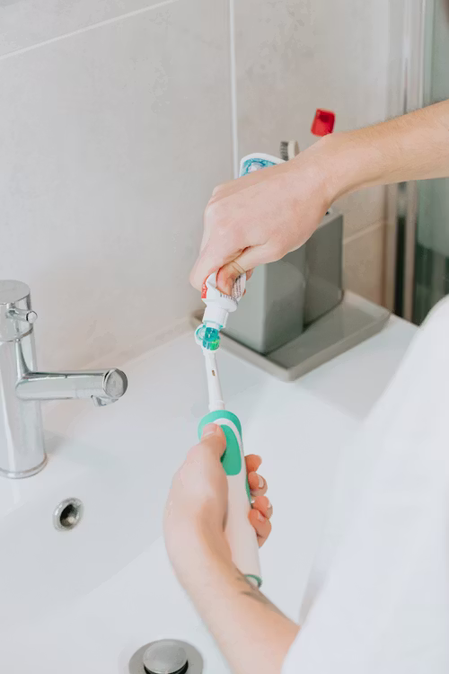 A calm flat-lay of water, a soft toothbrush and mint leaves